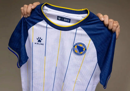 Nahaufnahme des Stoffs und Designs des weißen Bosnien KELME Auswärtstrikots WM 2026