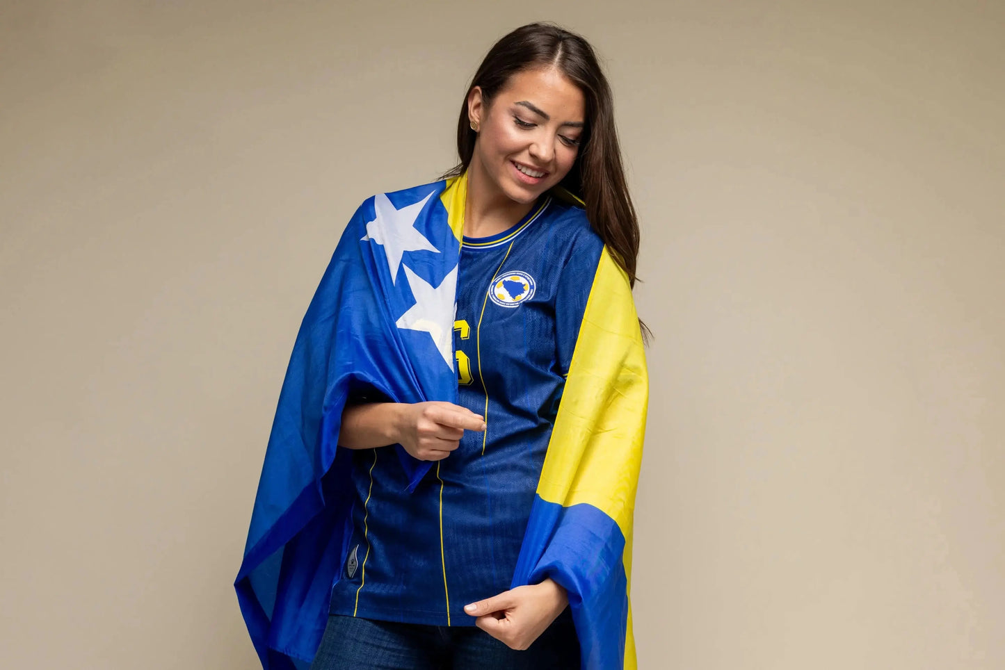 Frau im blauen BiH Heimtrikot hält bosnische Fahne – emotionales Bild WM 2026